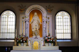 A serene altar adorned with candles and flowers dedicated to the Virgin Mary.