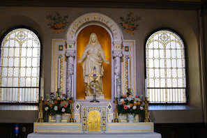 A serene altar adorned with candles and flowers dedicated to the Virgin Mary.