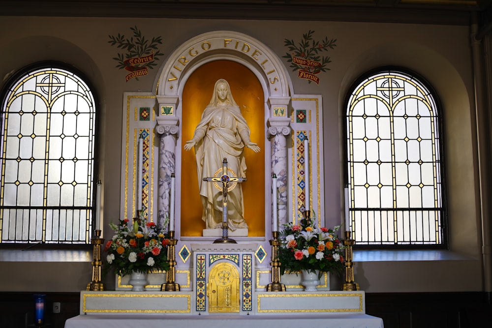 a statue of the virgin mary in front of stained glass windows