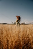 A person stretching outdoors under clear blue skies, soaking up the sun.