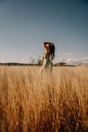 A person stretching outdoors under clear blue skies, soaking up the sun.