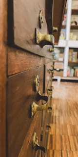 Close-up of a beautifully aged wooden dresser with intricate brass handles.