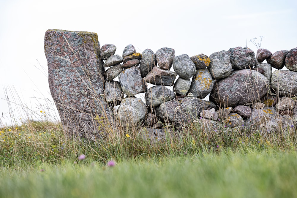 a stone wall made of rocks in a grassy field