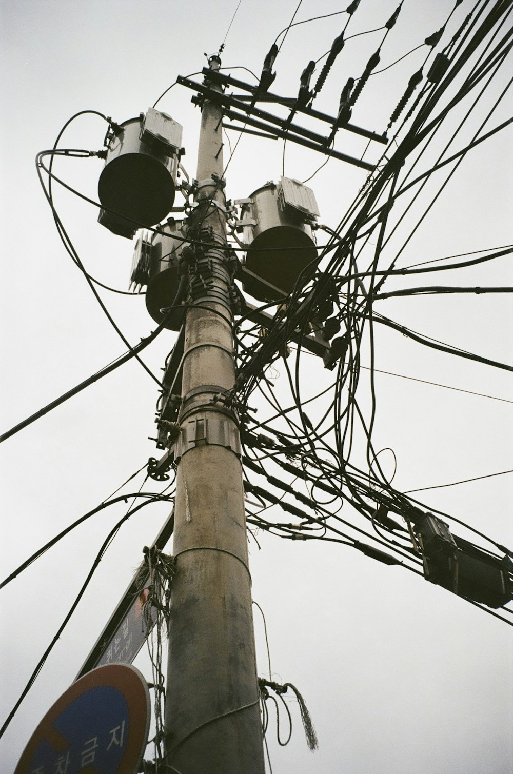 a pole with many electrical wires and a sign on it