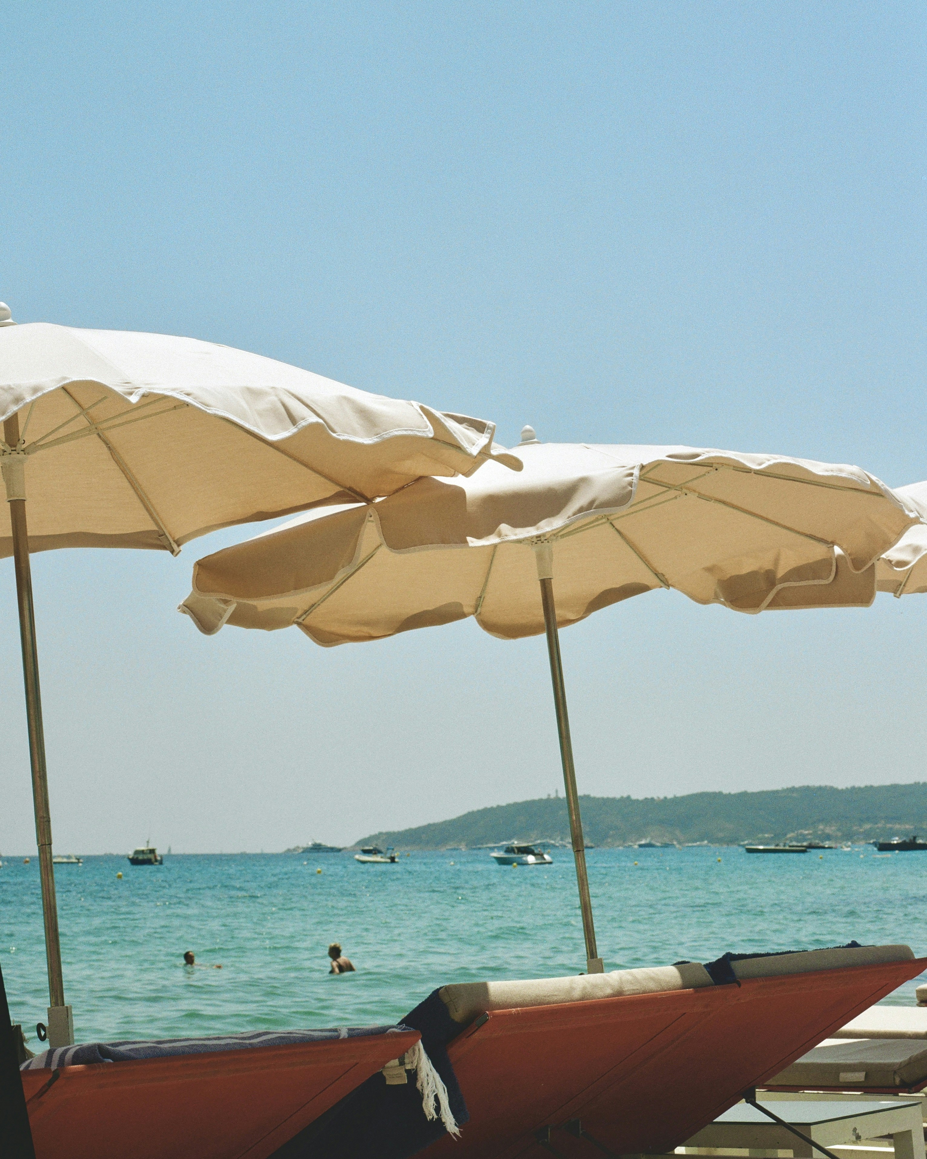 une rangée de parasols assis au sommet d’une plage