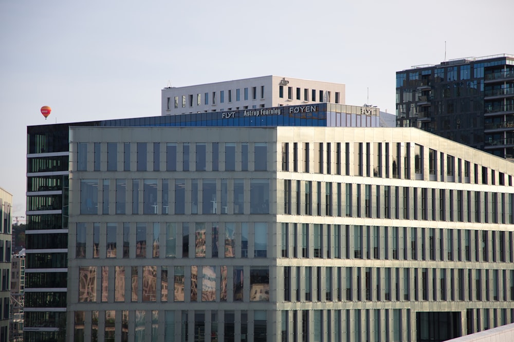 a large building with many windows and a red balloon in the sky