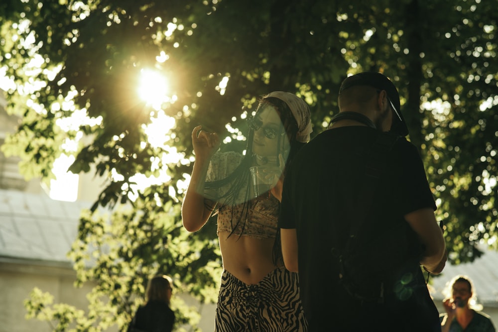 a man and a woman standing under a tree