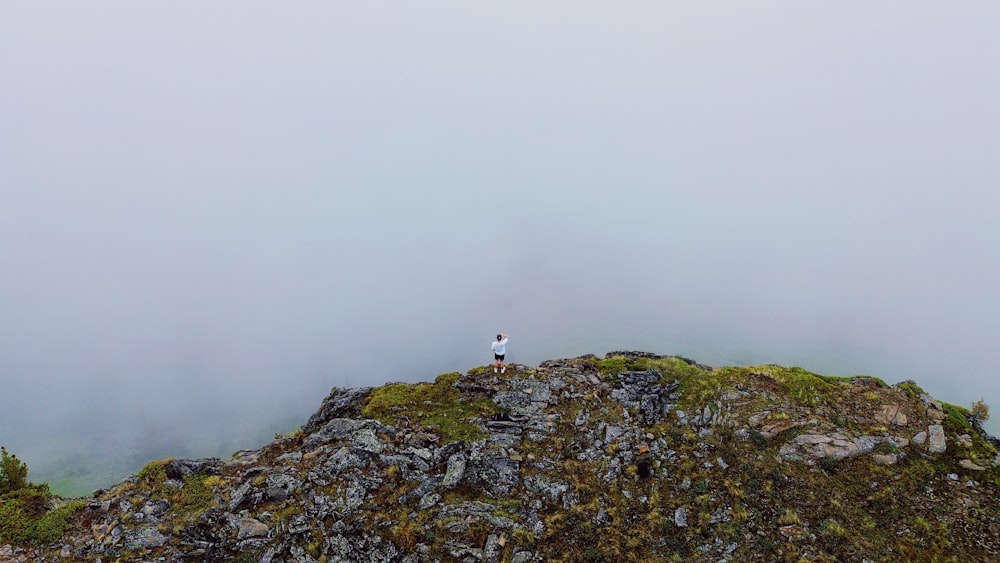 a lone person standing on top of a mountain