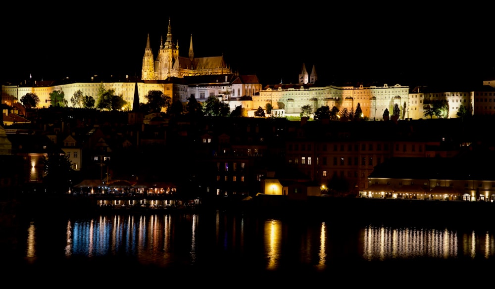 a night view of a city with a castle in the background