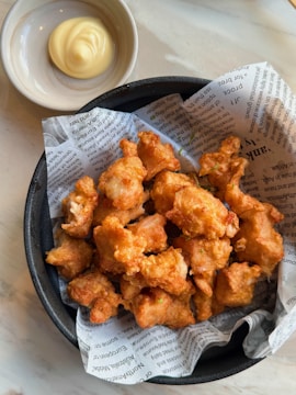 a bowl of fried food next to a bowl of mayonnaise