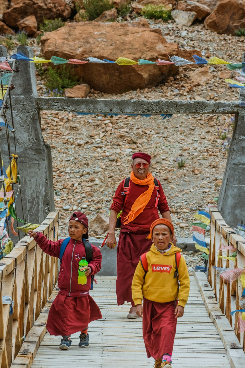 a group of people walking across a wooden bridge