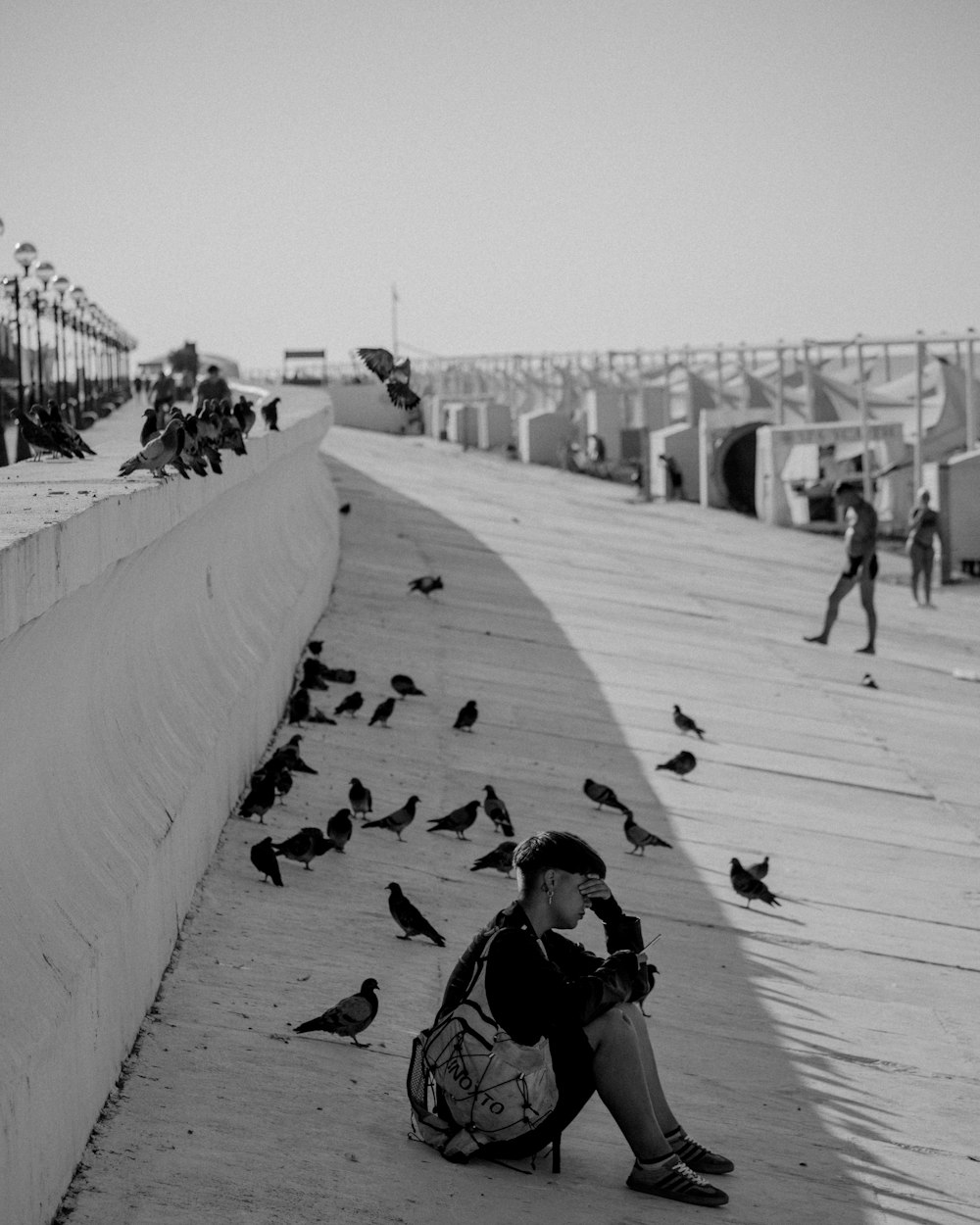 a person sitting on the ground with a bunch of birds