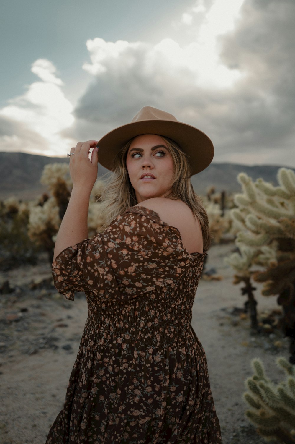 a woman wearing a brown dress and a brown hat