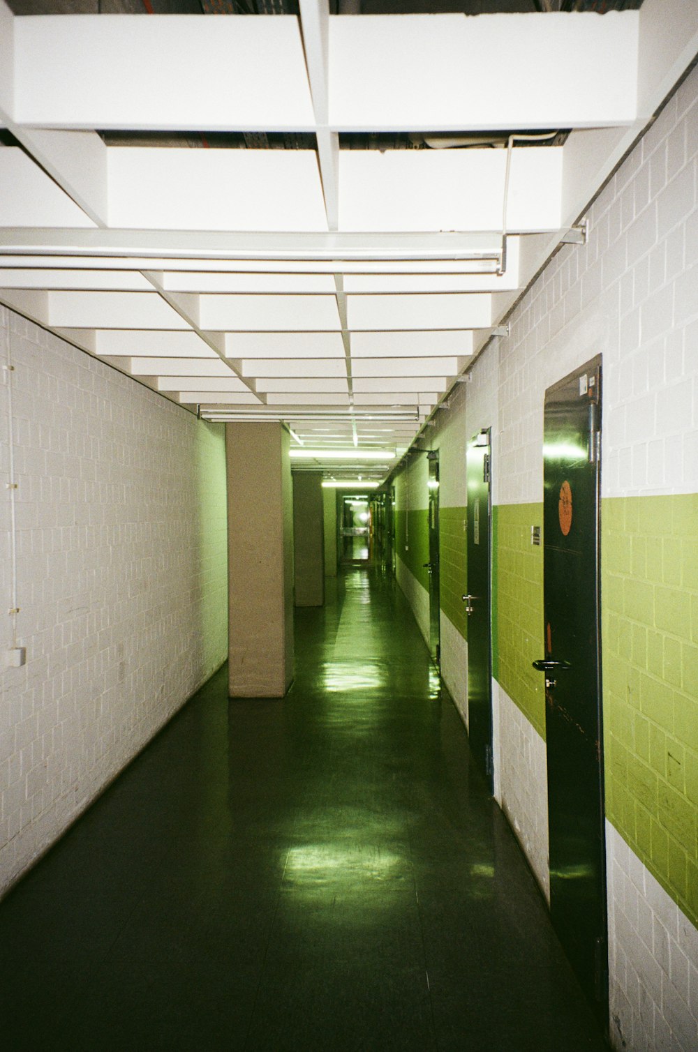 a long hallway with green and white walls