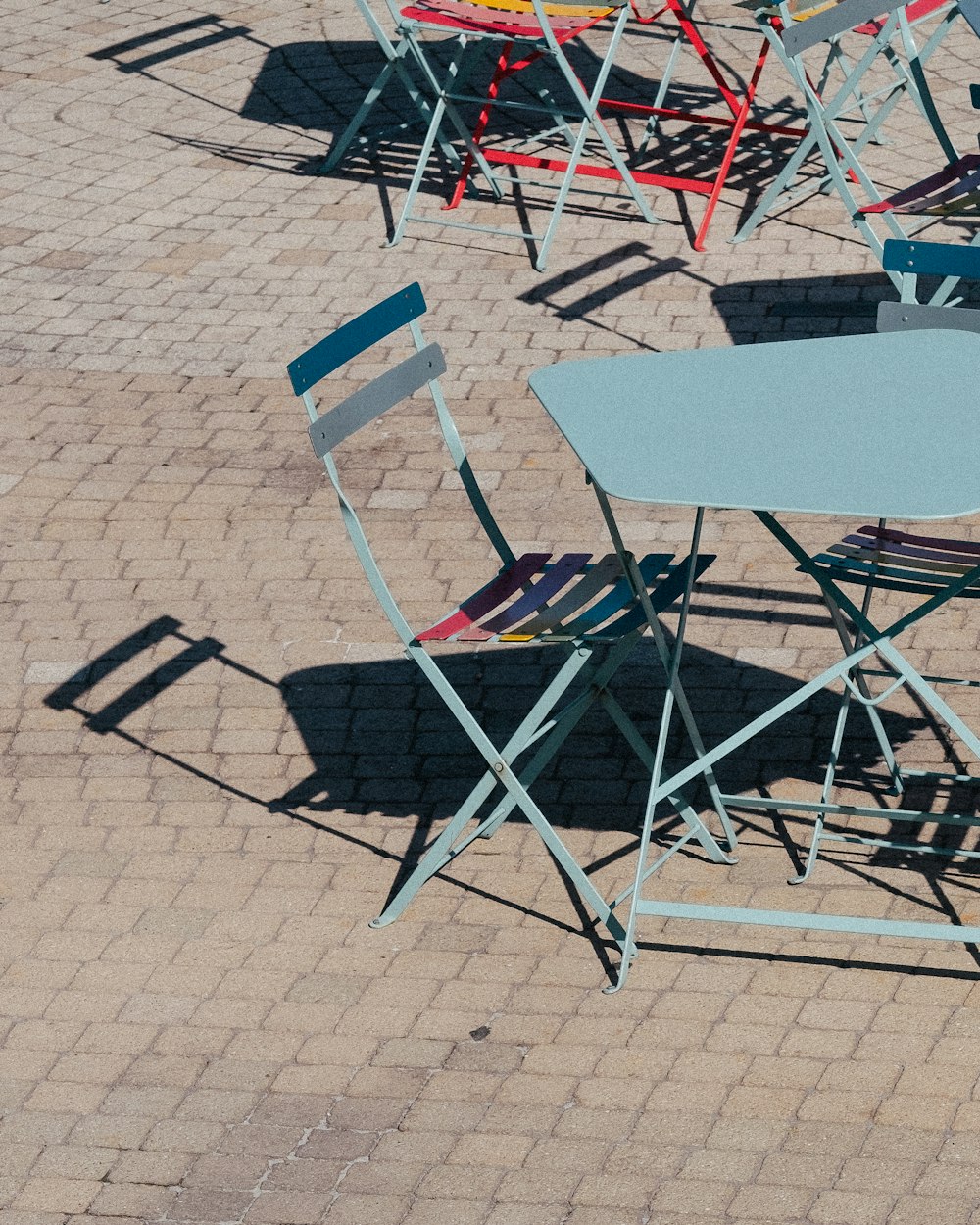 um grupo de cadeiras e uma mesa em uma calçada