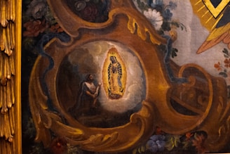 A detailed painting depicts a religious scene with a central figure illuminated by an intricate golden frame. Surrounding the figure are rich floral decorations and swirling ornate patterns in warm tones. The artwork conveys a sense of devotion and reverence.