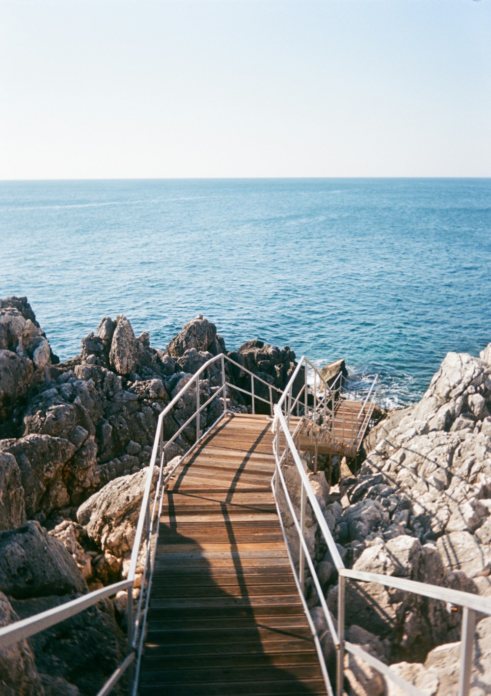 a stairway leading to the ocean on a sunny day