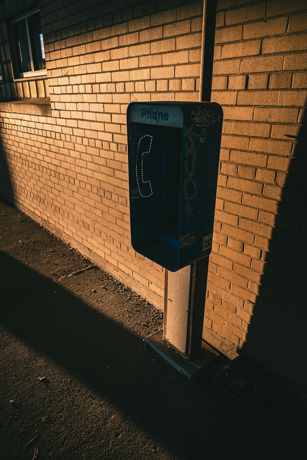 a parking meter sitting next to a brick wall