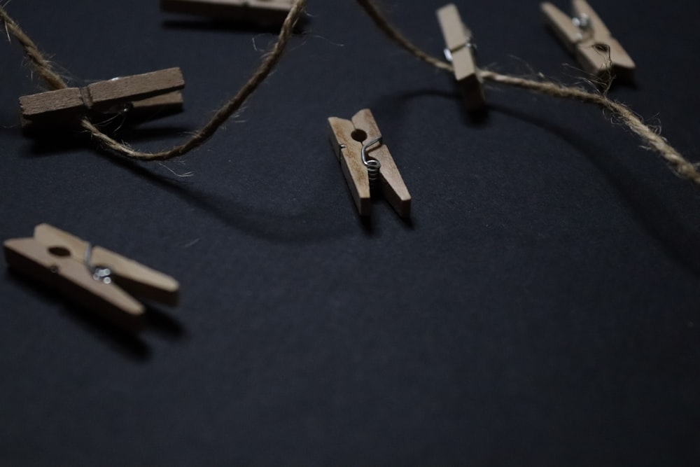 a bunch of wooden clothes pegs on a black surface