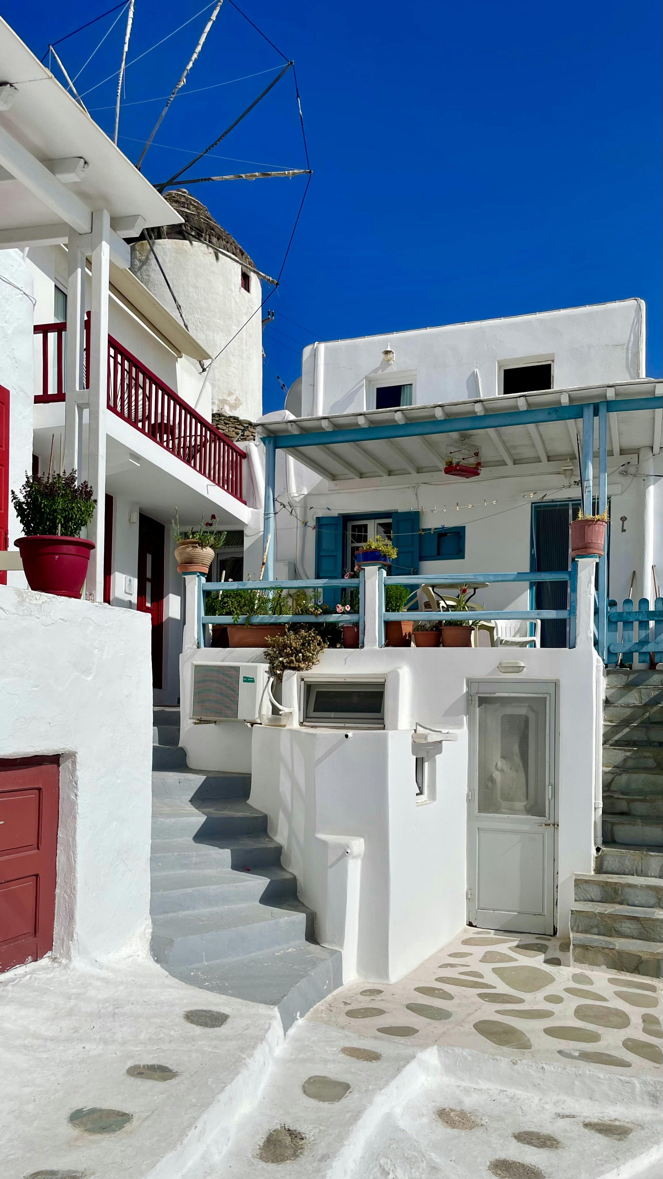 a white building with a red door and stairs