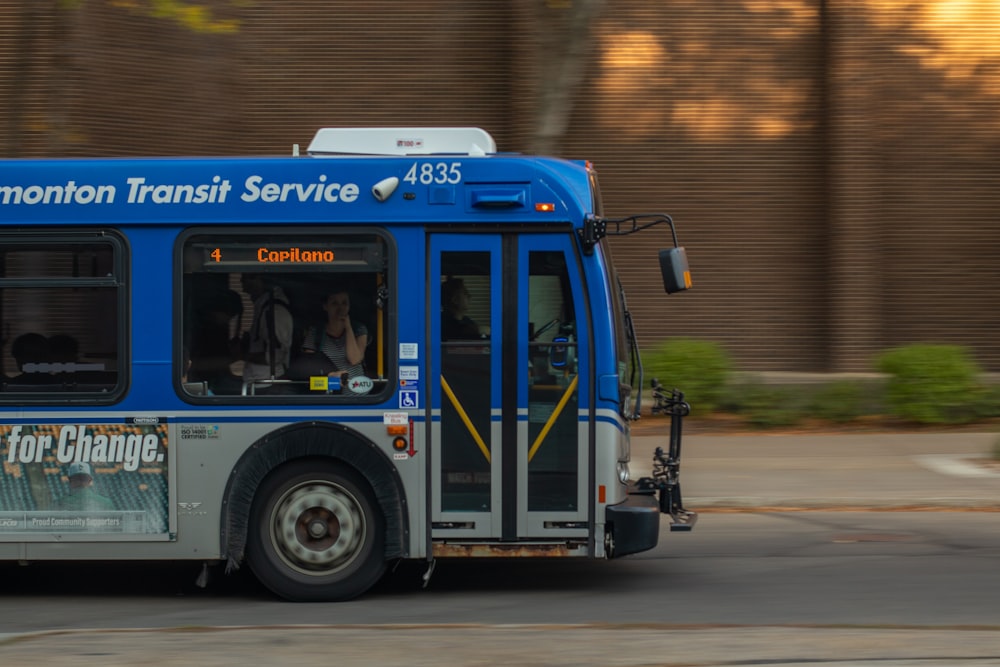 a blue and white bus driving down a street