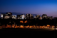 A cityscape at dusk with illuminated buildings and streets.
