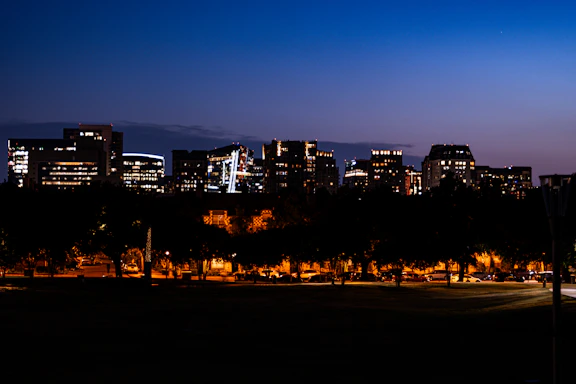 A calm urban skyline at dusk with soft lighting highlighting buildings and streets.