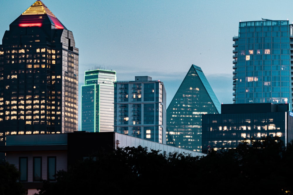 a city skyline with skyscrapers lit up at night