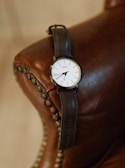 Finished wristwatch with a leather strap resting on a vintage clock face.