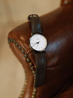 A classic wristwatch resting on a vintage leather bag, highlighting timeless style