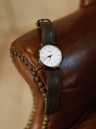 Finished wristwatch with a leather strap resting on a vintage clock face.