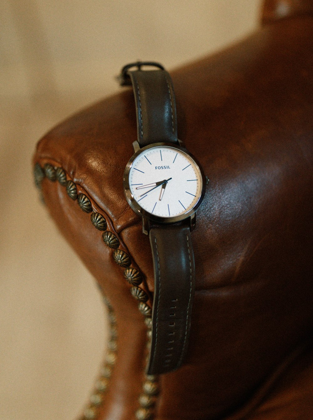 a watch sitting on top of a brown leather chair