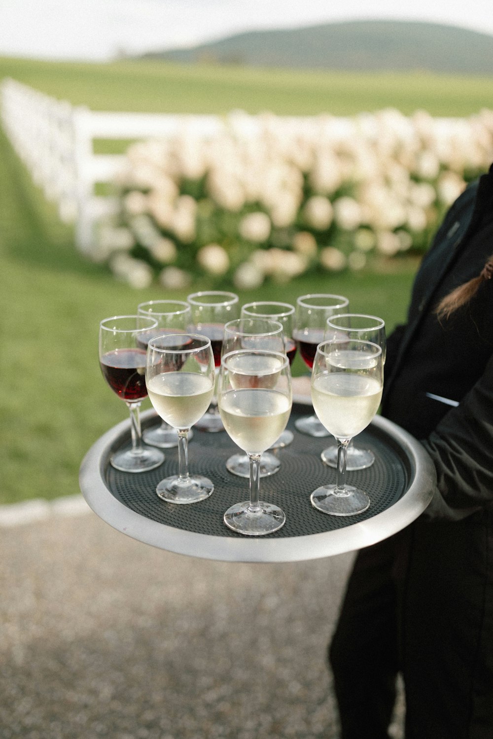a woman holding a tray of wine glasses