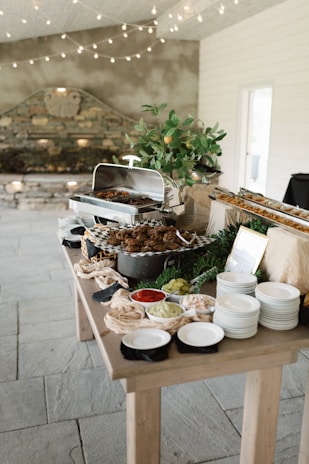 A wooden buffet serving tray stand holding assorted dishes and drinks.