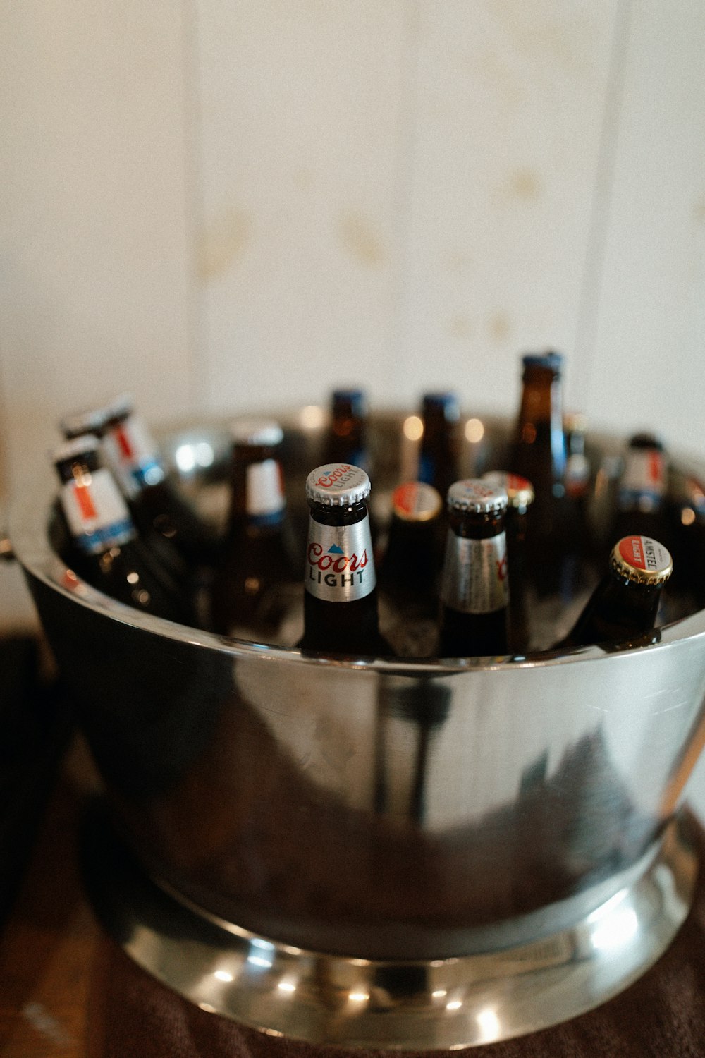 a metal bowl filled with bottles of beer