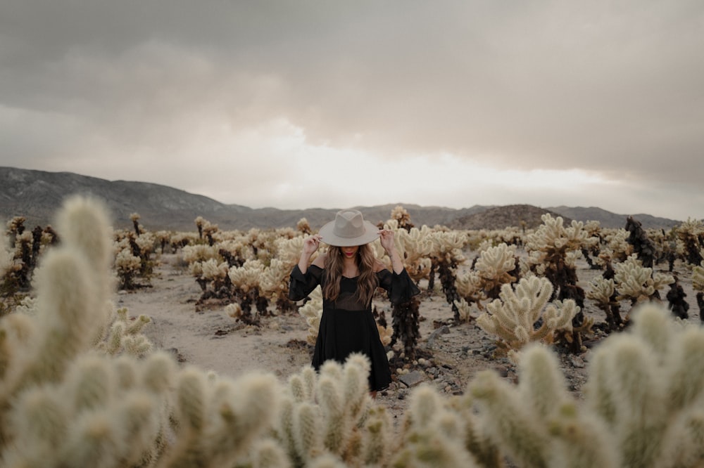 a woman standing in a field of cacti