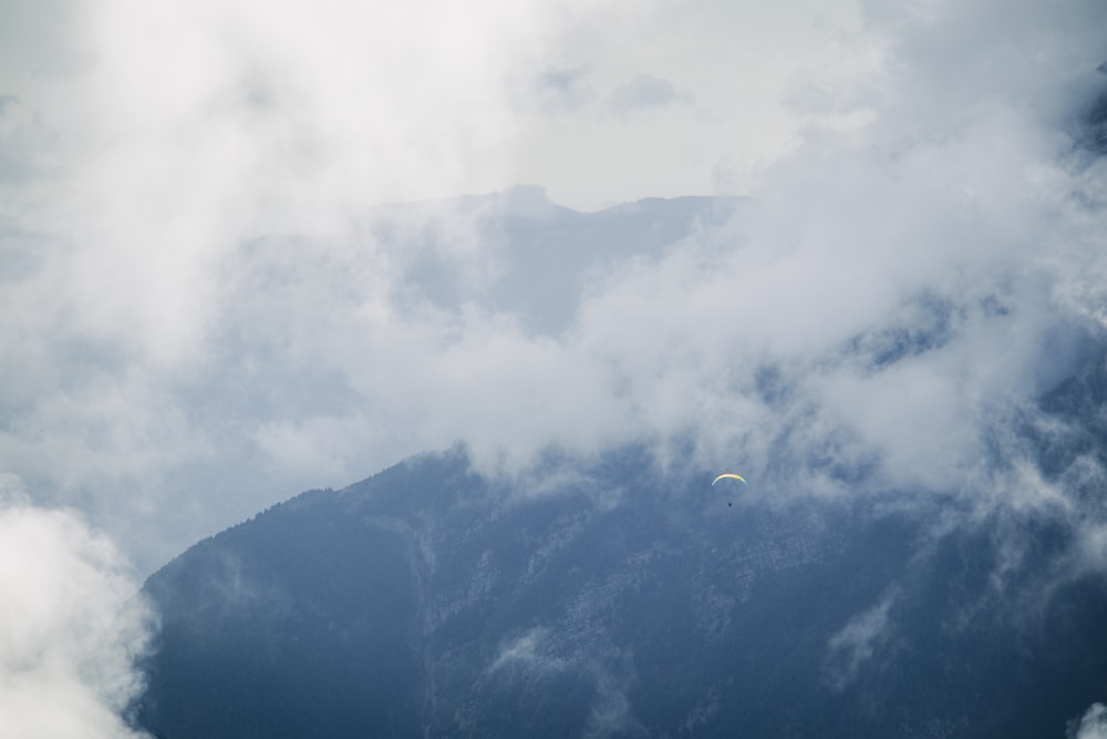 a kite flying in the sky with a mountain in the background