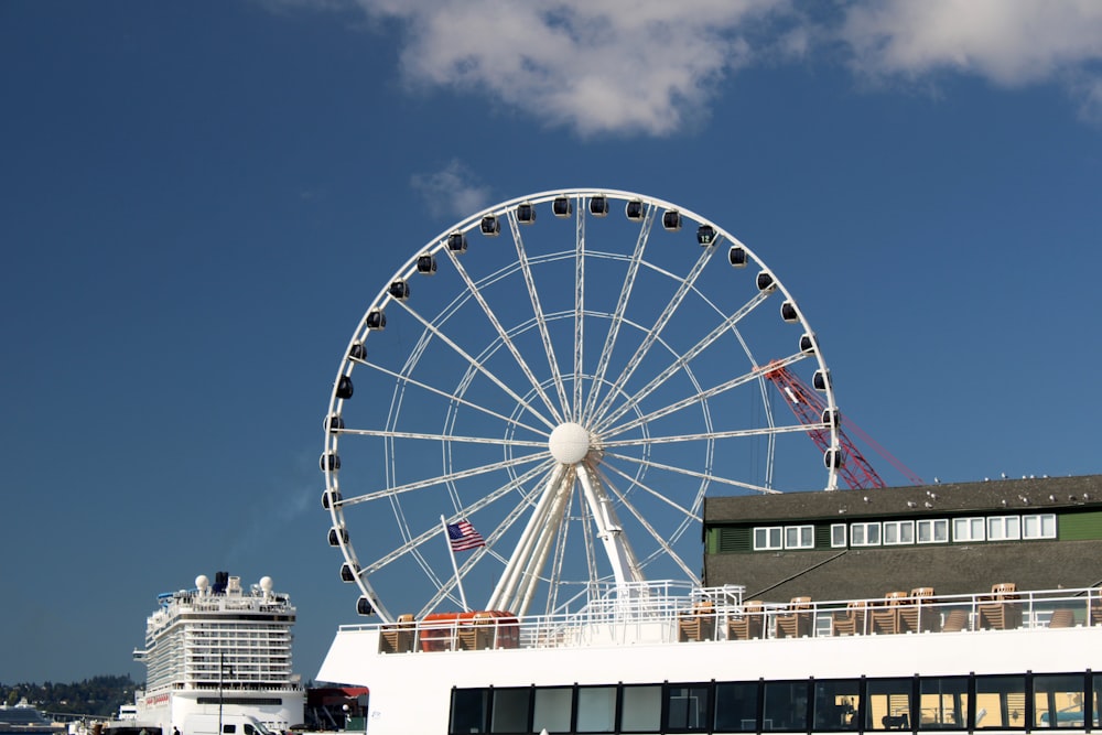 uma grande roda gigante sentada no topo de um edifício branco