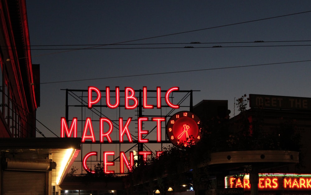 a public market center sign lit up at night