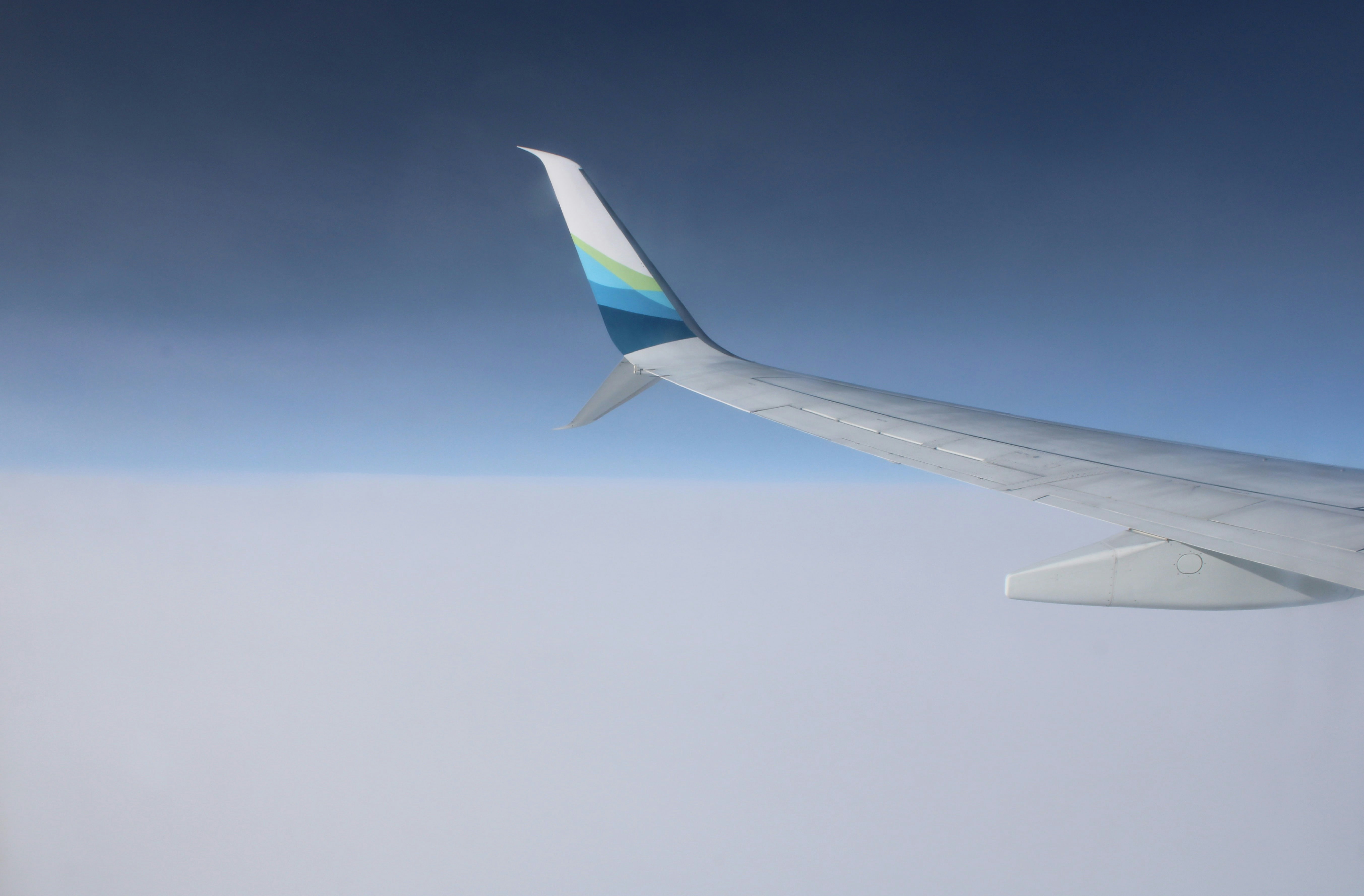 a view of the wing of an airplane in the sky