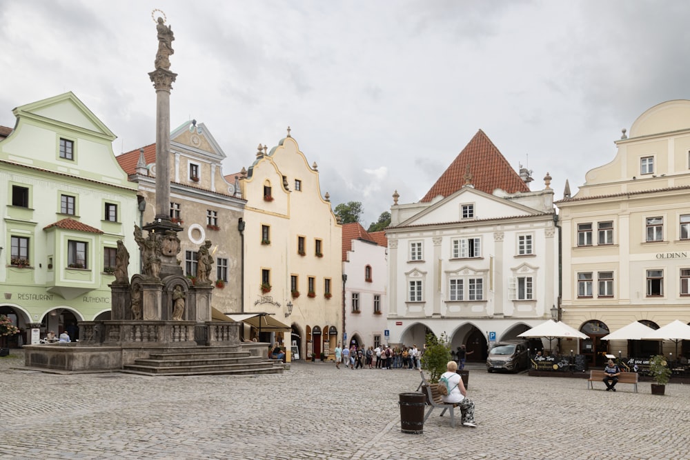 a person sitting on a bench in front of a fountain