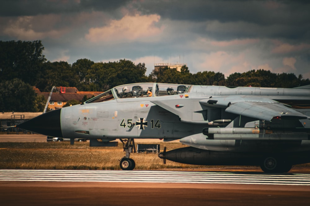 a fighter jet sitting on top of an airport runway