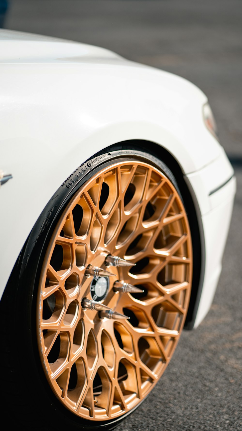 a close up of a white car with gold rims