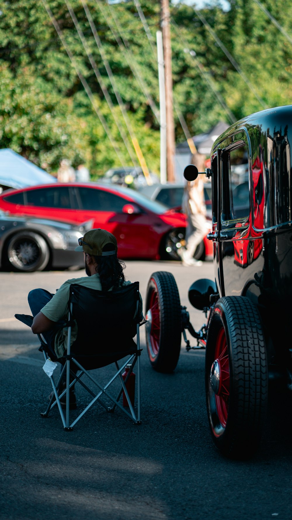 a man sitting in a chair next to a car