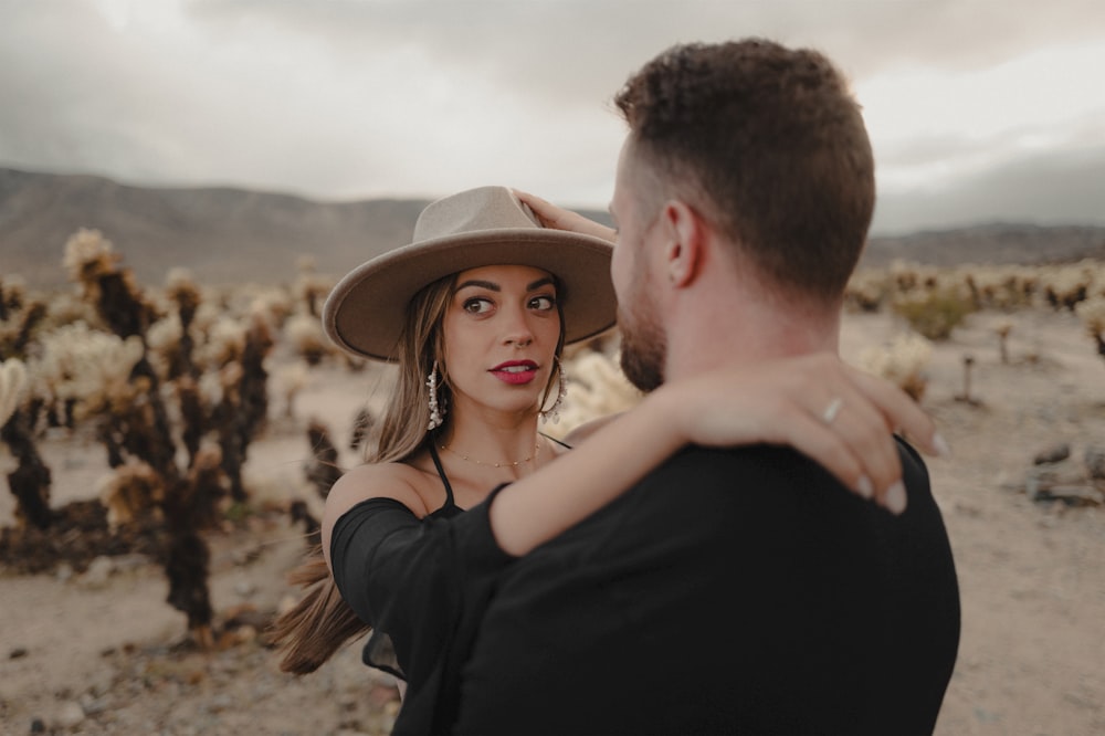 a man holding a woman in a desert