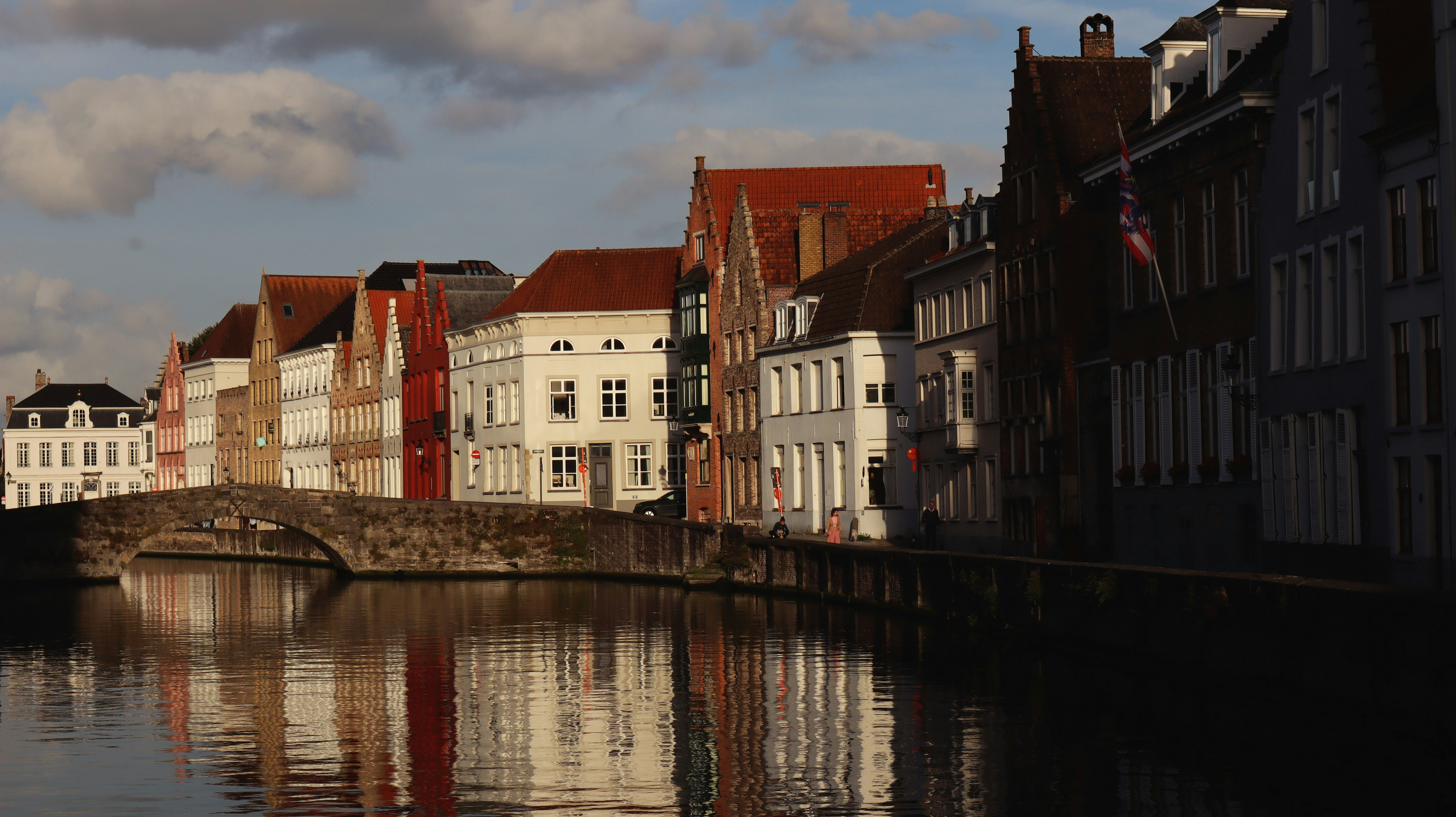 a river running through a city next to tall buildings, 