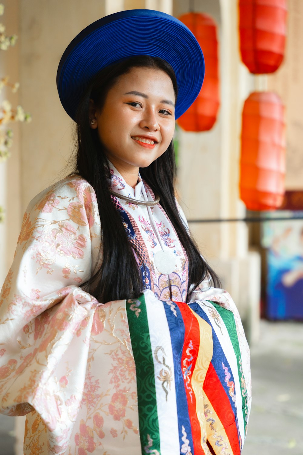 a woman wearing a colorful dress and a blue hat