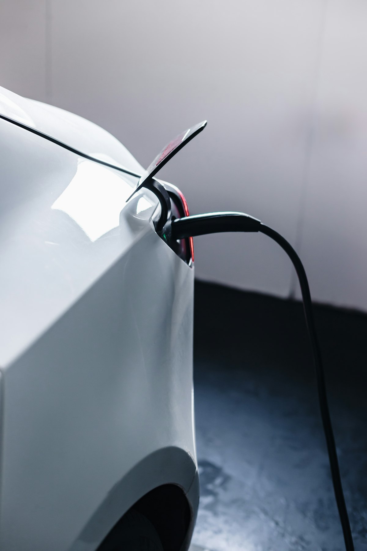 White electric vehicle plugged into a charger in a residential garage