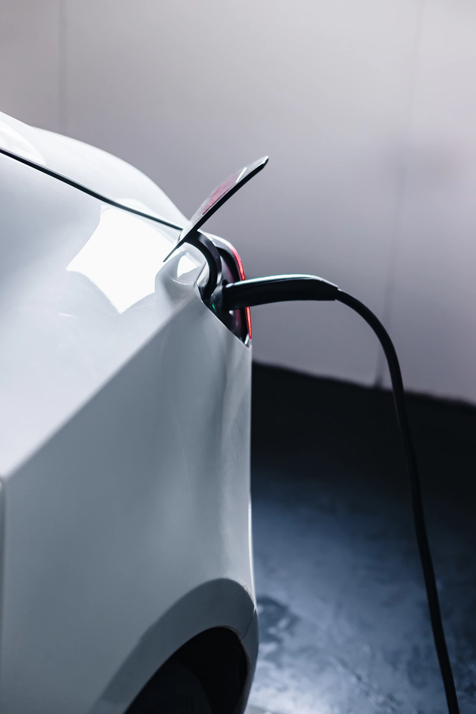 Electric vehicle charging cable connected to a car parked in a home garage