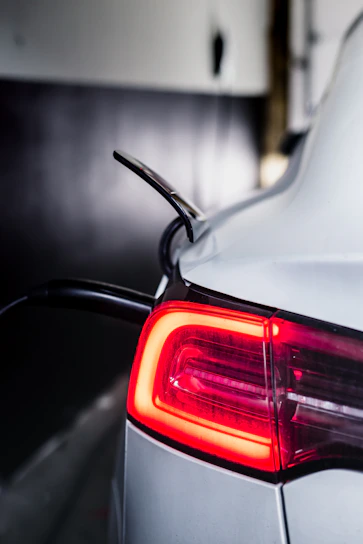 Phone charger plugged into a car’s cigarette lighter with a glowing LED indicator
